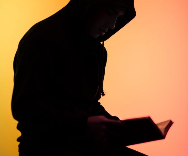 Silhouette of a person in a thoughtful pose against a schematic background.